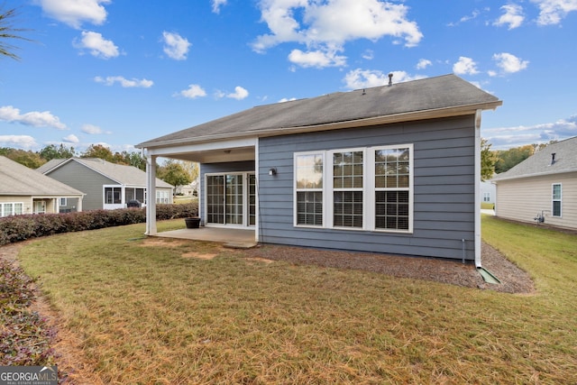 rear view of property featuring a yard and a patio area