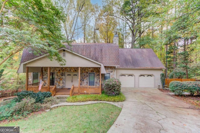 view of front facade with a garage, covered porch, and a front lawn