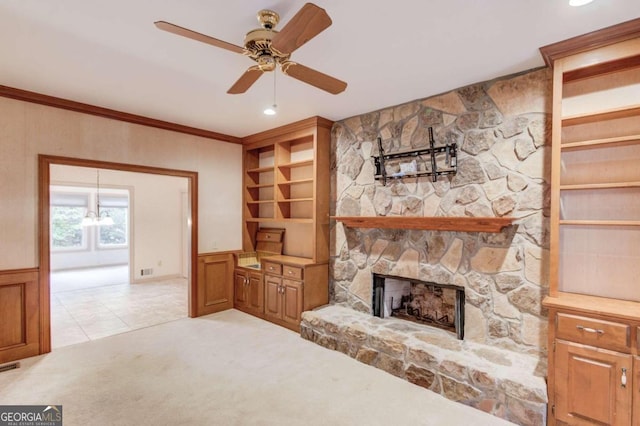 carpeted living room featuring ceiling fan with notable chandelier, a fireplace, and crown molding