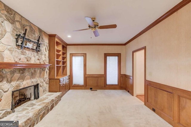 carpeted living room featuring ceiling fan, ornamental molding, and a fireplace