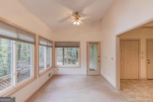 interior space with ceiling fan, light colored carpet, and vaulted ceiling