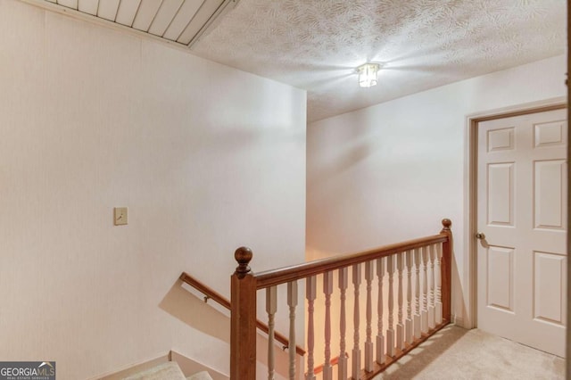 stairs with carpet flooring and a textured ceiling