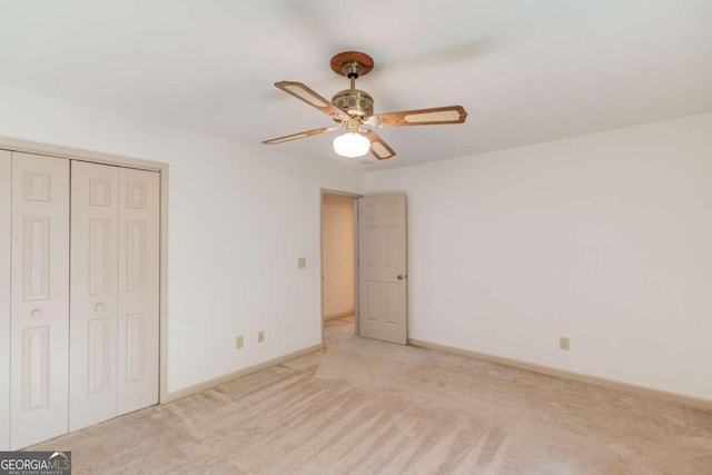 unfurnished bedroom with a closet, light colored carpet, and ceiling fan