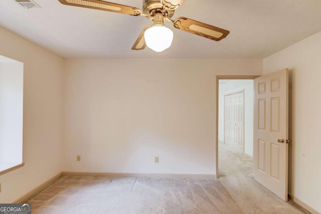 empty room featuring light carpet and ceiling fan