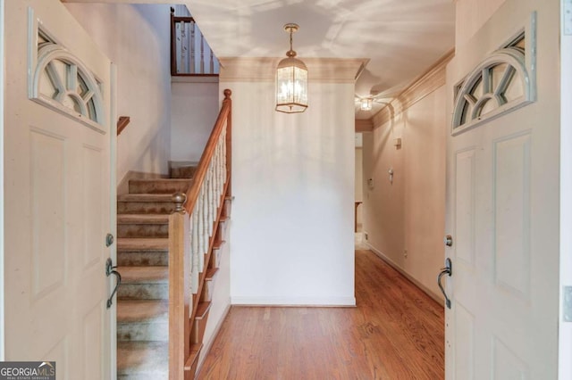 entryway featuring hardwood / wood-style floors, a notable chandelier, and ornamental molding