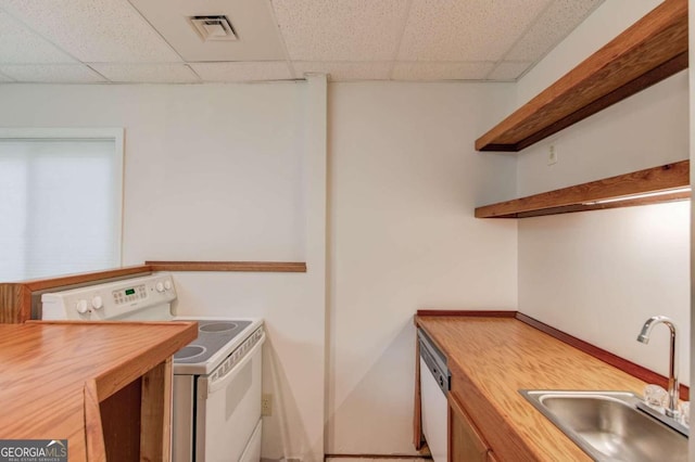 kitchen featuring white appliances, butcher block countertops, a paneled ceiling, and sink