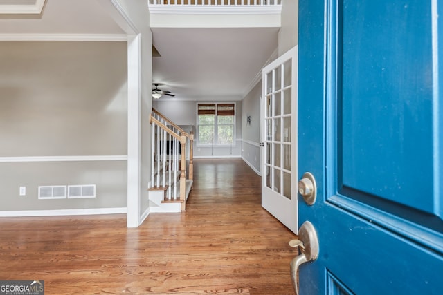 foyer entrance featuring hardwood / wood-style flooring, ceiling fan, ornamental molding, and french doors