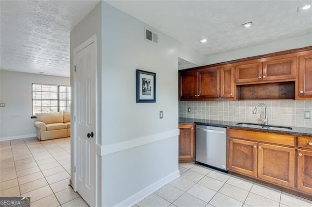 kitchen featuring dishwasher, backsplash, dark stone counters, sink, and light tile patterned flooring