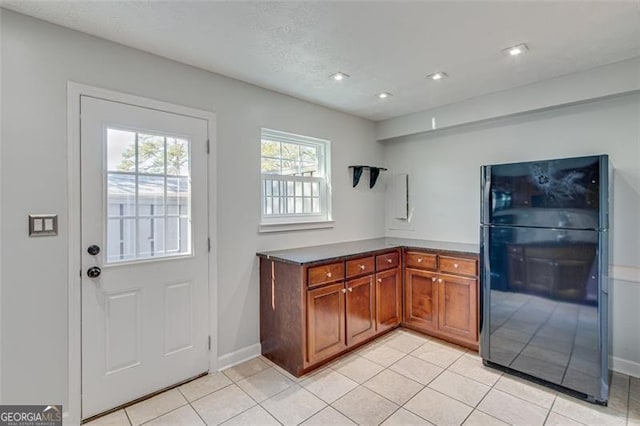 kitchen featuring black refrigerator and light tile patterned floors