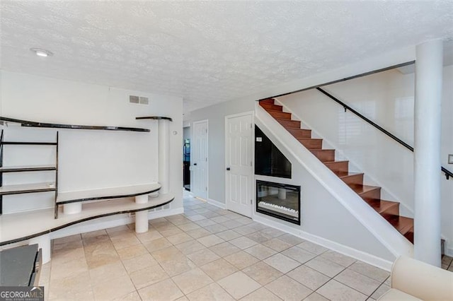 interior space with light tile patterned floors and a textured ceiling