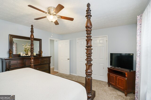 carpeted bedroom with a textured ceiling and ceiling fan