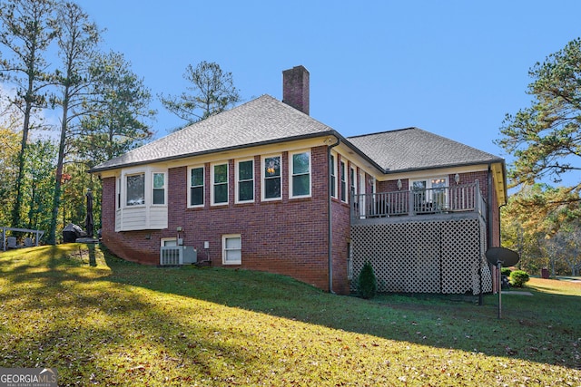 exterior space featuring central AC unit, a yard, and a wooden deck