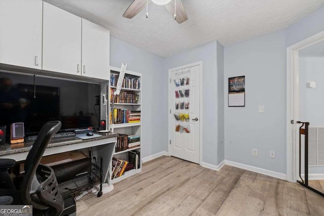 office space with ceiling fan, a textured ceiling, and light wood-type flooring