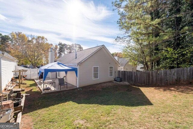 rear view of house with a lawn, a patio area, and a gazebo