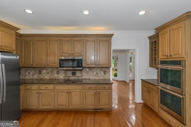 kitchen featuring backsplash, stainless steel appliances, crown molding, and light hardwood / wood-style floors