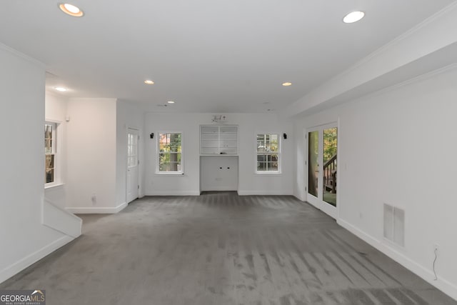 unfurnished living room featuring carpet and ornamental molding