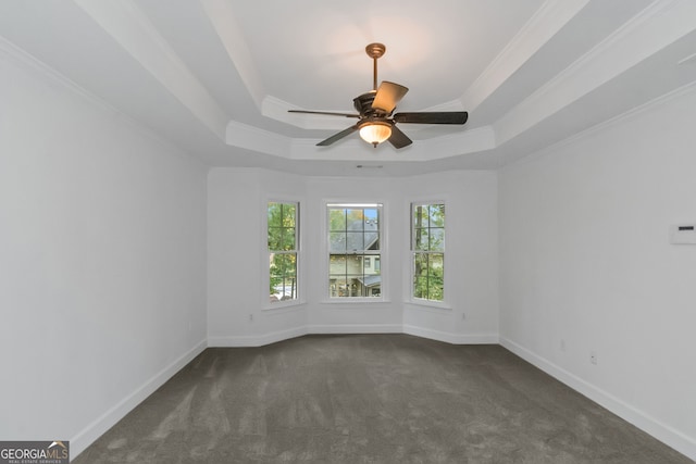 carpeted spare room featuring ceiling fan, ornamental molding, and a tray ceiling