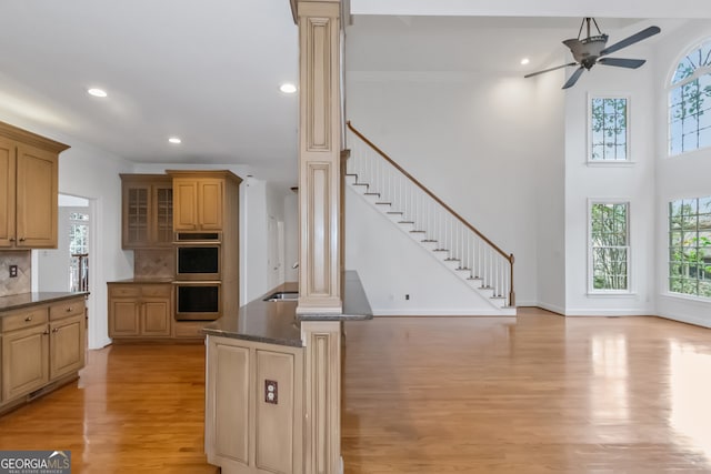 kitchen with backsplash, decorative columns, light hardwood / wood-style flooring, and plenty of natural light