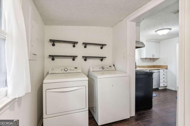 laundry area featuring dark hardwood / wood-style floors, washing machine and dryer, and a textured ceiling