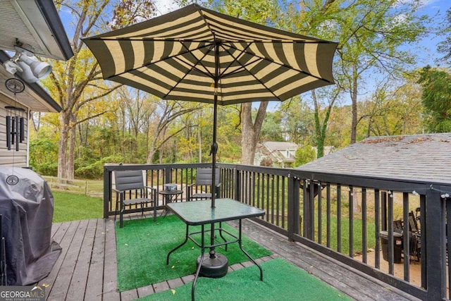 wooden terrace featuring a grill and a yard