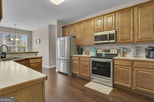 kitchen with sink, an inviting chandelier, dark hardwood / wood-style flooring, decorative light fixtures, and appliances with stainless steel finishes