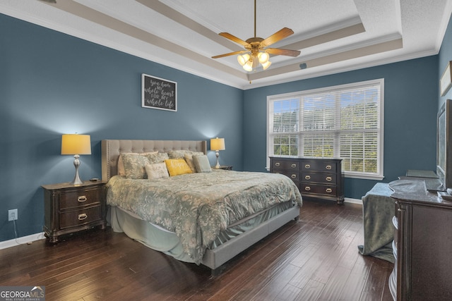 bedroom with a raised ceiling, crown molding, ceiling fan, dark hardwood / wood-style floors, and a textured ceiling