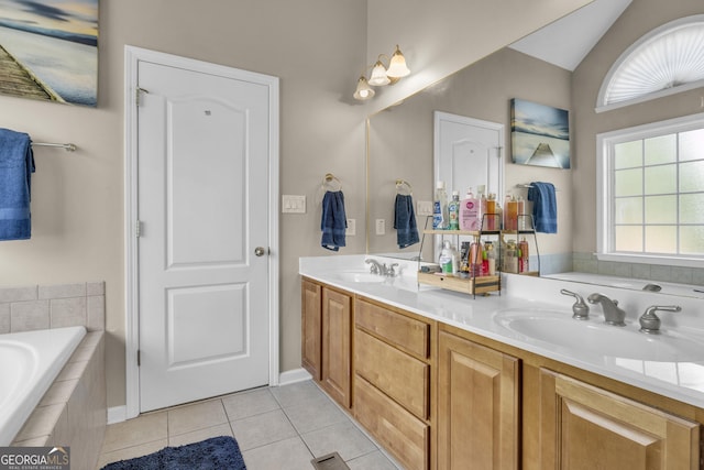 bathroom with vanity, a relaxing tiled tub, tile patterned floors, and vaulted ceiling