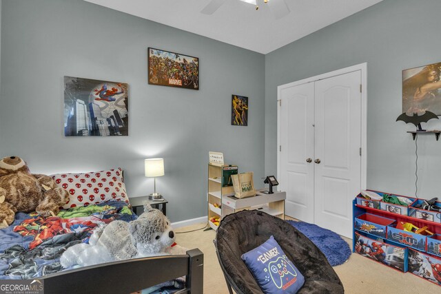 carpeted bedroom with ceiling fan and a closet