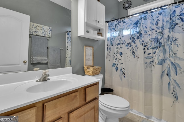 bathroom with tile patterned flooring, vanity, toilet, and curtained shower