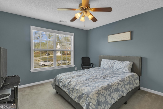 bedroom with carpet flooring, a textured ceiling, and ceiling fan