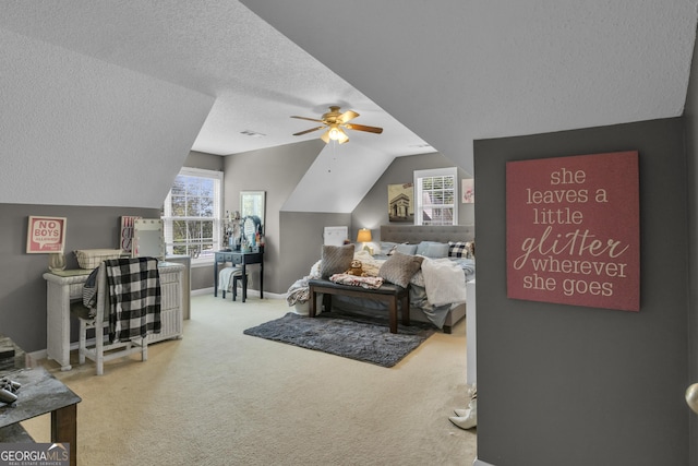 bedroom with a textured ceiling, carpet floors, vaulted ceiling, and ceiling fan