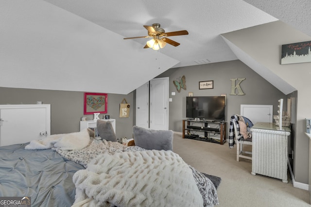 bedroom featuring a textured ceiling, ceiling fan, light carpet, and vaulted ceiling