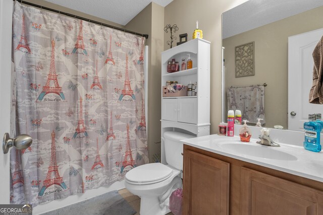 bathroom featuring vanity, a textured ceiling, and toilet