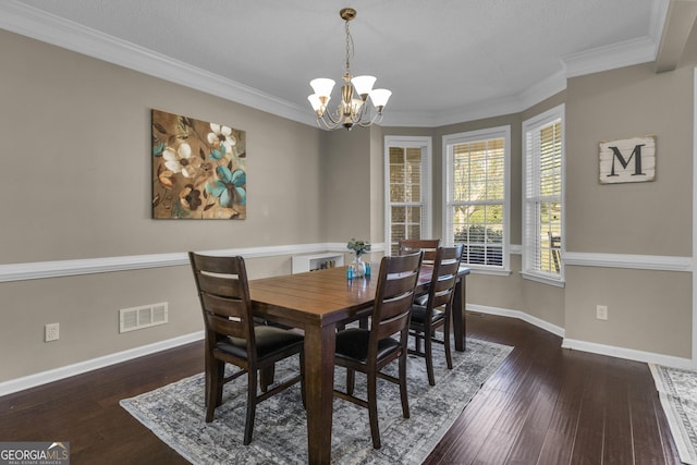 dining room featuring crown molding, dark hardwood / wood-style flooring, a chandelier, and a textured ceiling