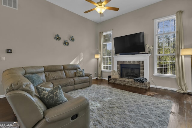 living room featuring a fireplace, dark hardwood / wood-style floors, and ceiling fan