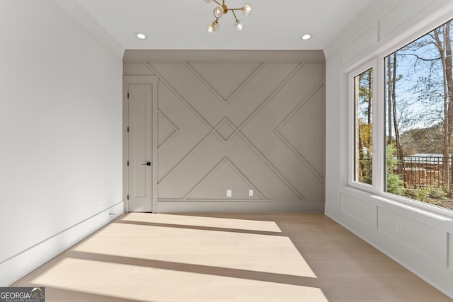 empty room with light hardwood / wood-style flooring and a notable chandelier