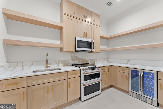 kitchen featuring sink, stainless steel appliances, wine cooler, light stone counters, and light brown cabinetry