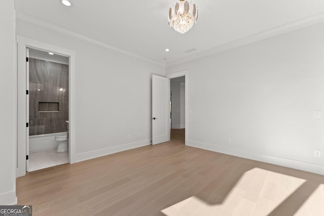 bedroom with connected bathroom, crown molding, light hardwood / wood-style flooring, and a chandelier