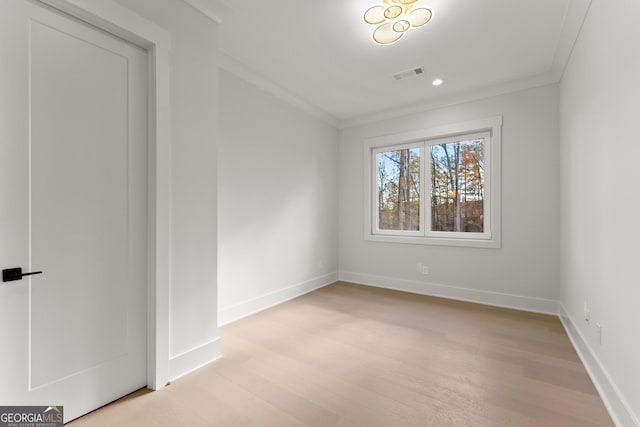 unfurnished room featuring light wood-type flooring and crown molding