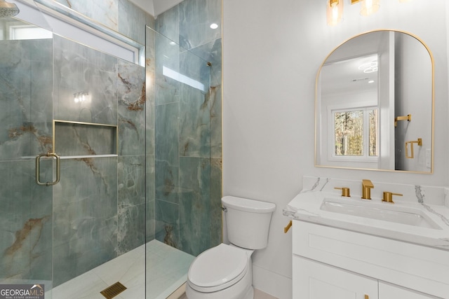 bathroom featuring vanity, toilet, and a shower with shower door