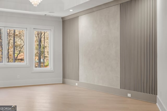 empty room featuring a chandelier and wood-type flooring