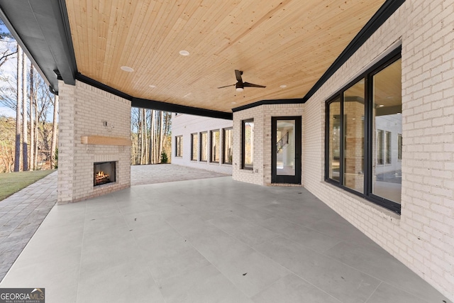 view of patio / terrace with ceiling fan and an outdoor brick fireplace