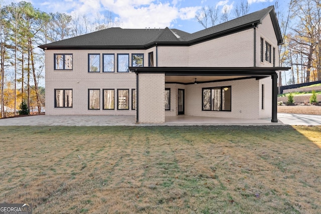 back of house featuring a lawn and a patio area