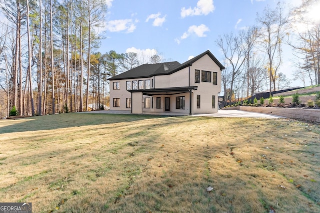 back of property with a patio area and a lawn