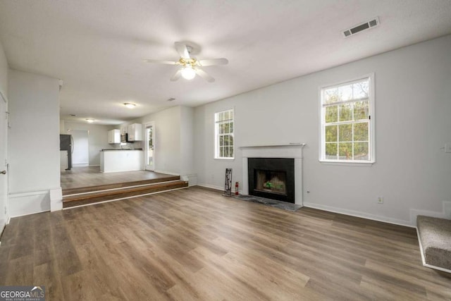 unfurnished living room featuring ceiling fan and hardwood / wood-style floors