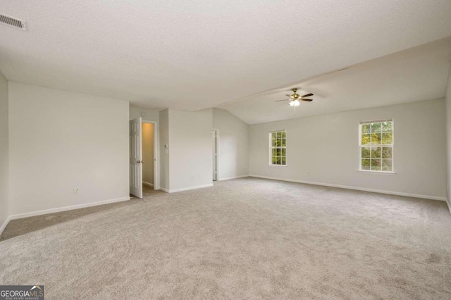 carpeted empty room with ceiling fan, a textured ceiling, and vaulted ceiling