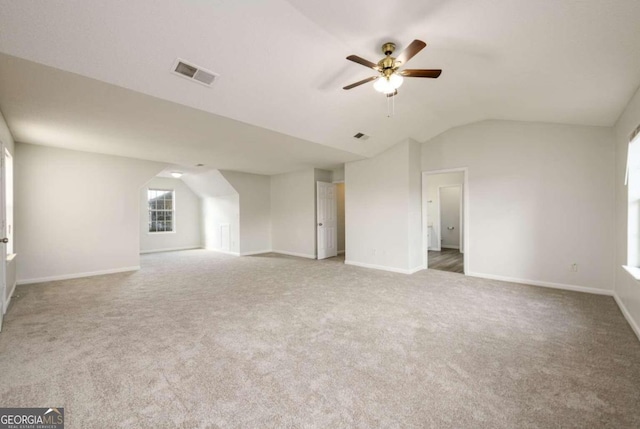 unfurnished living room with carpet, ceiling fan, and vaulted ceiling