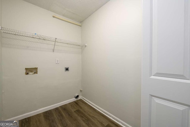 clothes washing area featuring electric dryer hookup, hookup for a washing machine, a textured ceiling, and dark hardwood / wood-style floors