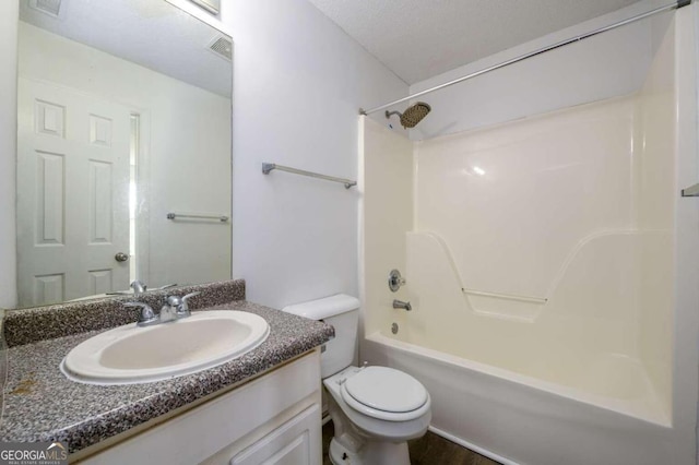 full bathroom with vanity, toilet, a textured ceiling, and bathing tub / shower combination