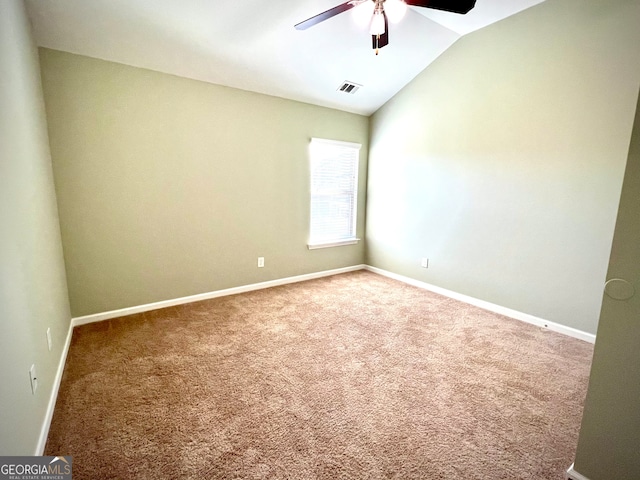 carpeted spare room with ceiling fan and vaulted ceiling